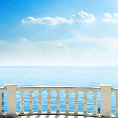 Fototapeta na wymiar white balcony on sea beach and clouds in sky