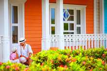 Cute Father And Son Sitting And Talking On Porch, Caribbean Street