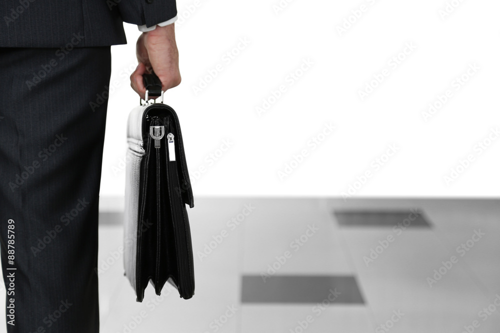 Man holding suitcase on light background