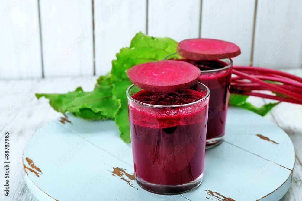 Glasses of beet juice with vegetables on table close up