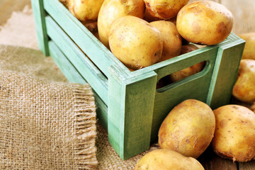 Wall Mural - Young potatoes in crate on table close up