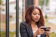 © michaelheim - Afro-American Office Woman Texting on her Phone