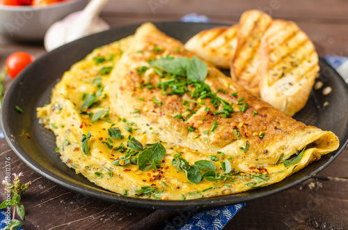 Cuadros en Lienzo Herb omelette with chives and oregano sprinkled with Herb omelette with chili fl