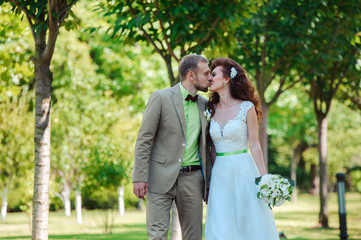 Wall Mural - Bride and groom in green summer park