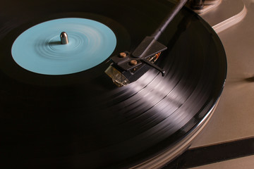 Rotating vinyl record with a blue mark on the turntable selective focus