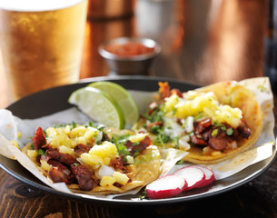 Wall Mural - tasty plate of mexican street tacos with beer in background