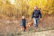 © Soloviova Liudmyla - Son with father carry full basket of mushrooms in autumn forest