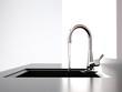 water flows from the kitchen tap to black kitchen sink