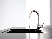 Water Flows From The Kitchen Tap To Black Kitchen Sink
