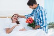 © WavebreakmediaMicro - Man offering flowers to pregnant woman in hospital
