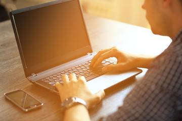 Man's hands typing on laptop keyboard