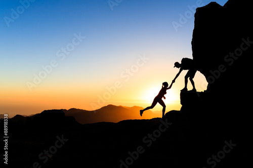 Fotografia Teamwork couple climbing helping hand
