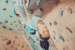 © Alex Photo - Smiling young woman climbing indoor