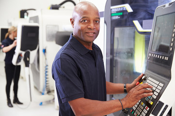 Wall Mural - Portrait Of Male Engineer Operating CNC Machinery In Factory