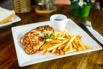 Scrambled eggs and french fries on a wooden table