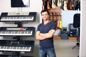 Wall Mural - Handsome young man in music store