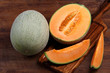 Organic cantaloupe with utensils on wooden table