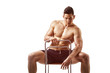 Muscular young bodybuilder sitting on chair