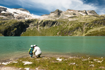 Wall Mural - mother with child relaxing near glacier lake in austrian alps