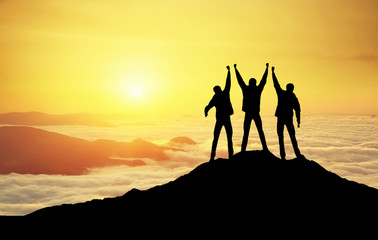 Wall Mural - silhouettes of team on mountain peak. sport and active life concept.