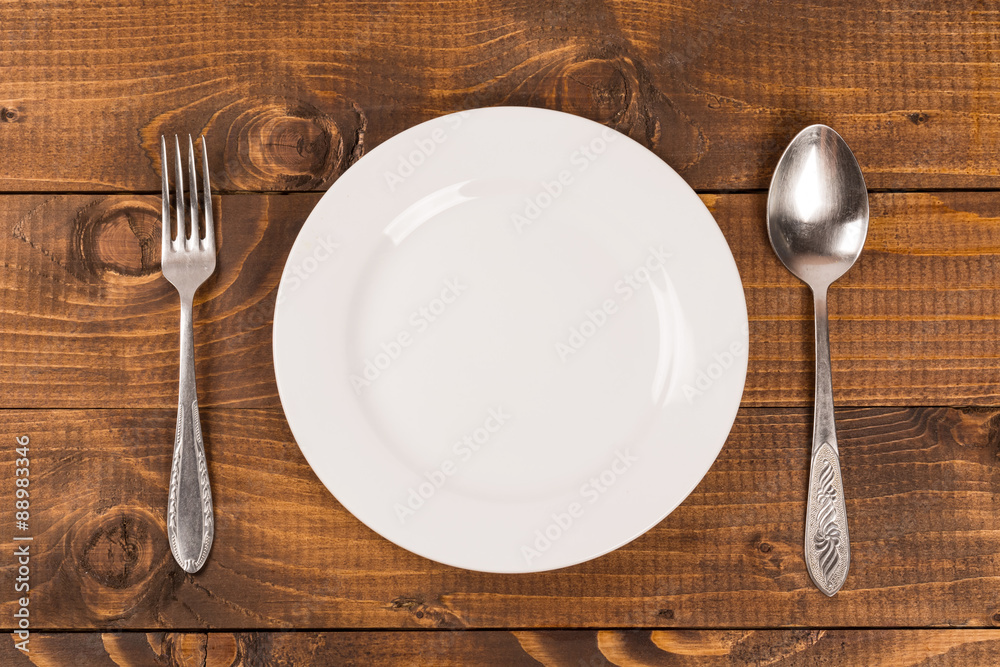 Foto de Stock spoon and fork on a plate on the table Adobe Stock