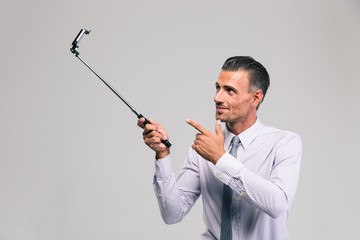 Poster - Handsome businessman holding selfie stick