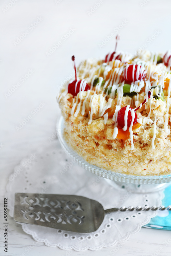 Butter cake with cherries on stand, on color wooden background