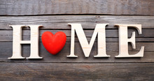 Decorative Letters Forming Word HOME With Heart On Wooden Background