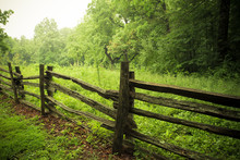 Rustic Wooden Fence Along Countryside With Greenery 