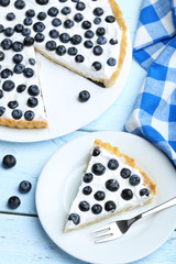 Sweet tart cake with blueberries on blue wooden background