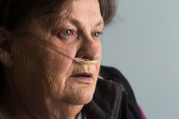 elderly woman breathing supplemental oxygen