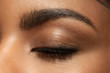 Close-up closed eye with make-up with brown eyebrows and black lashes