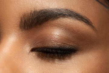 Wall Mural - Close-up closed eye with make-up with brown eyebrows and black lashes