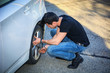 © theartofphoto - Handsome Young Man Changing Tires of his Car