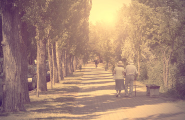 Vintage photo of old couple walking in the park