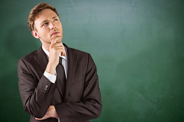 Canvas Print - Composite image of young businessman thinking with hand on chin