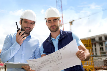 Wall Mural - Engineer and worker checking plan on construction site