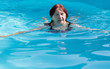 Active senior  woman in her 60s swimming in a pool. Space copy available, healthy lifestyle and rejuvenation concept