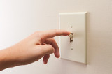 Fototapeta Miasta - Hand turning wall light switch off. color image in horizontal orientation