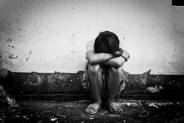  asian girl sad alone sitting near old wall cement,black and whi