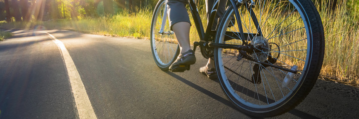 Bike on the asphalt path illuminated by sun.