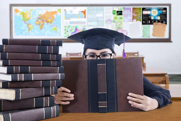 Wall Mural - Graduate student cover her face with book