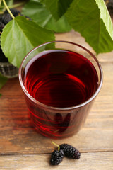 Wall Mural - Glass of refreshing mulberry juice with berries on table close up