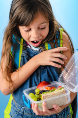 Cute school girl is surprised to see what's inside her healthy l