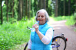 Seniorin trinkt Wasser während  Radtour