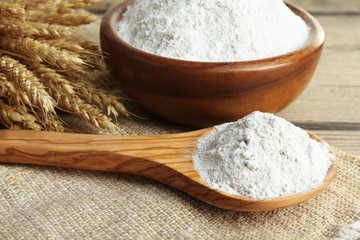 Sticker - Whole flour in bowl with wheat ears on wooden table, closeup