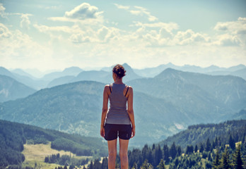 Wall Mural - young woman admiring a mountaintop view