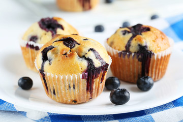 Poster - Tasty blueberry muffins on a white wooden background