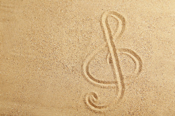 Violin key drawn on a beach sand