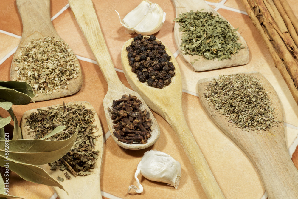 Allspice berries, cumin seeds, and dried oregano on a plate